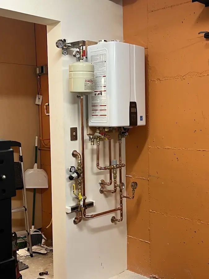 Plumbing technician inspecting water heater connections in West Mifflin